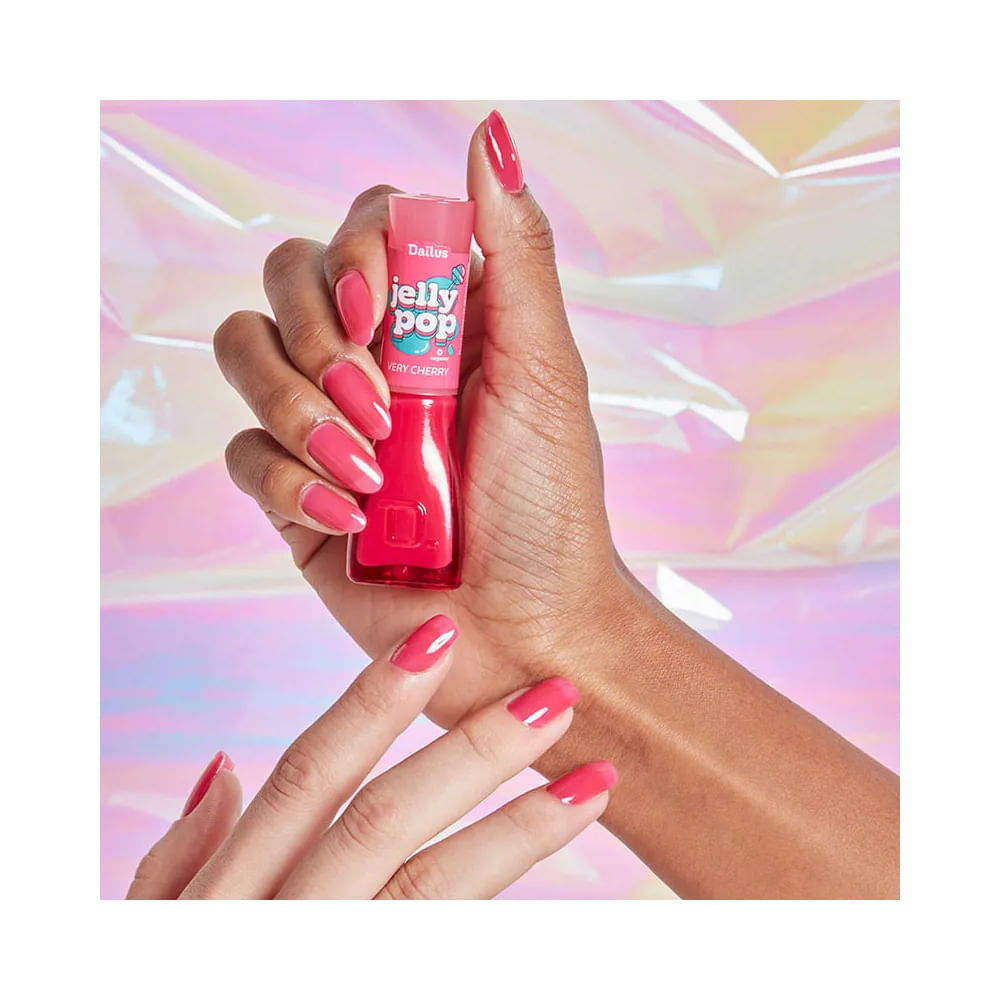 Mão segurando esmalte Dailus Jelly Pop Very Cherry com unhas pintadas na mesma cor